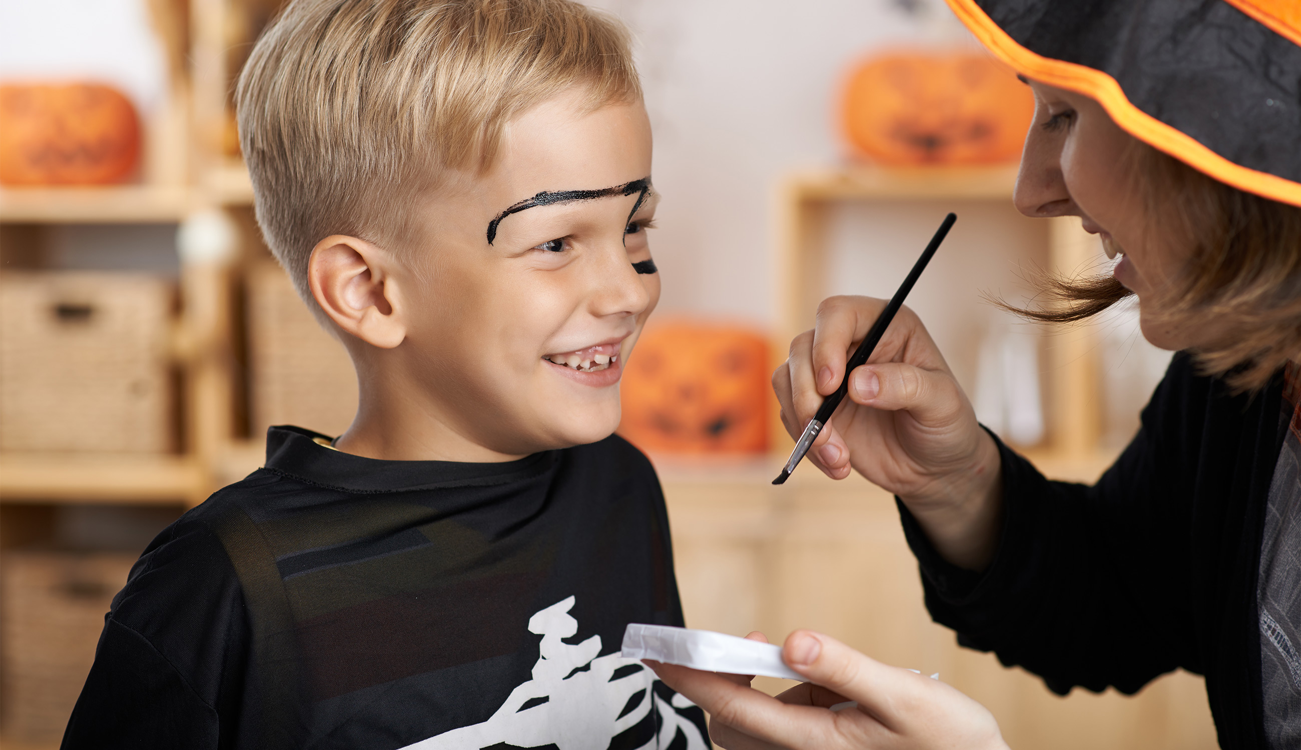Bambini sorridenti con truccabimbi per Halloween dai colori vivaci